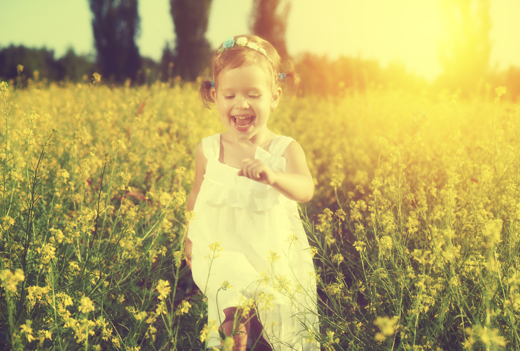 happy little child girl in a white dress running on field with a bouquet of yellow flowers, wildflowers